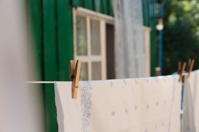 Photo of Washing line with clean laundry and clothespins outdoors, closeup. Space for text