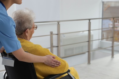 Nurse assisting senior woman in wheelchair at hospital