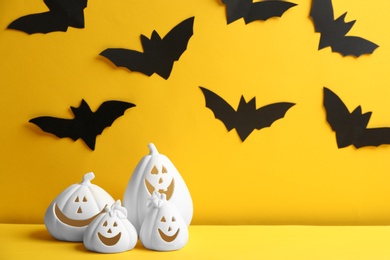 Photo of Jack-o-Lantern candle holders on yellow background. Halloween decor