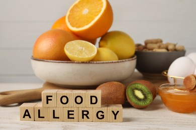 Image of Food allergy. Different fresh products and cubes on light wooden table