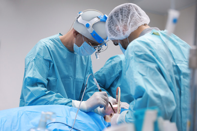 Photo of Professional doctors performing 
frontal sinus trephination in surgery room