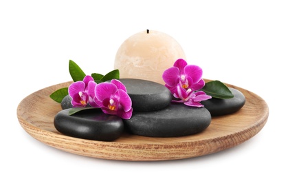 Photo of Wooden tray with spa stones, orchid flowers and candle on white background