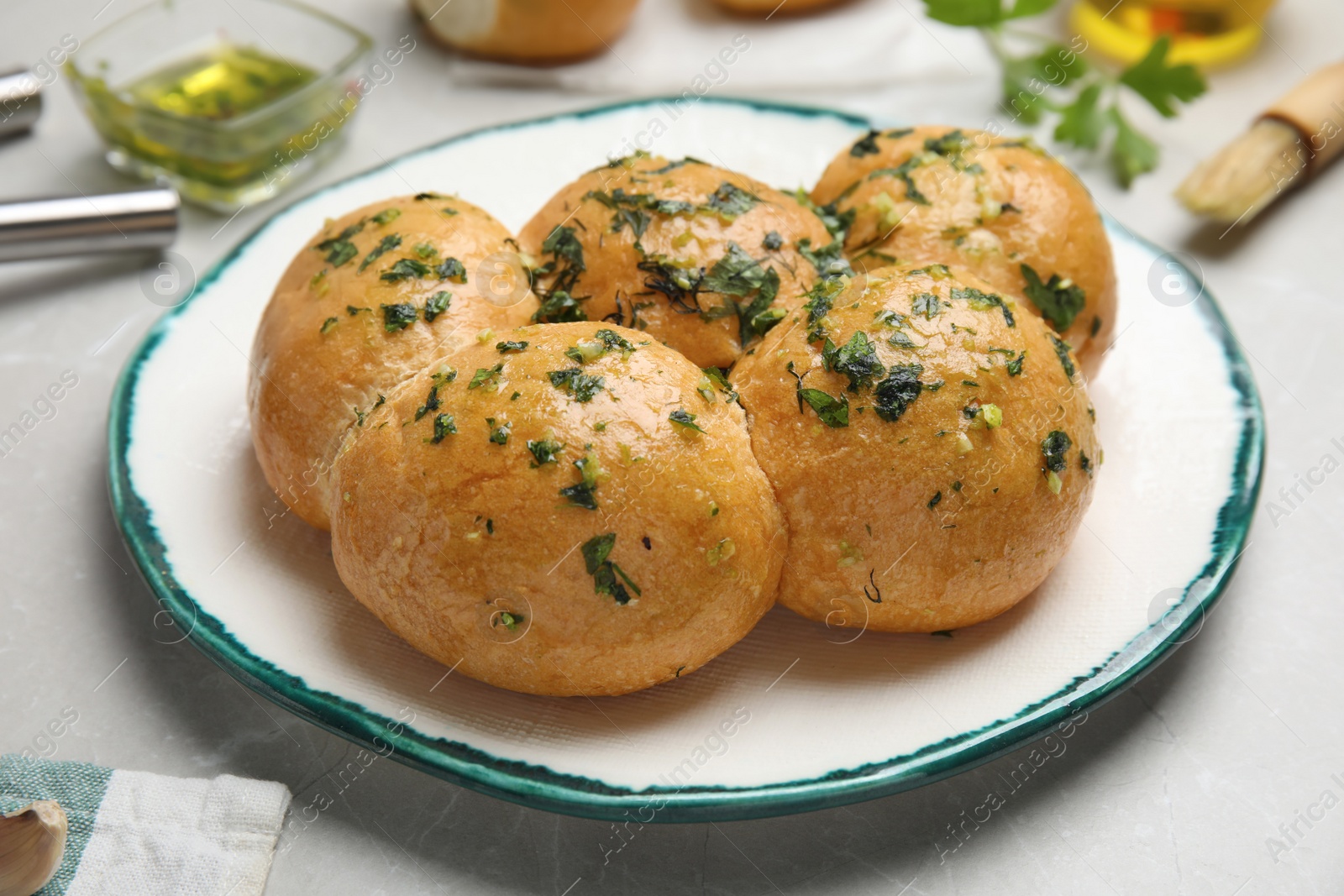 Photo of Traditional Ukrainian bread (Pampushky) with garlic on light table