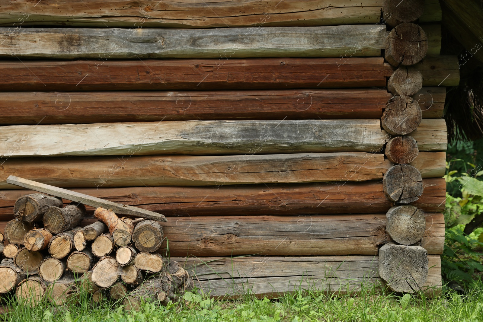 Photo of Pile of cut firewood near house on summer day, space for text