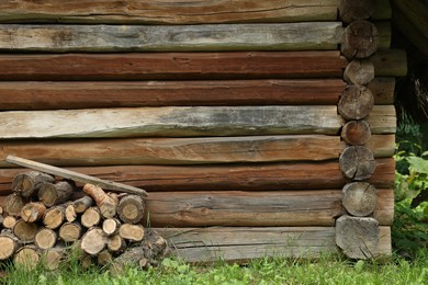 Pile of cut firewood near house on summer day, space for text