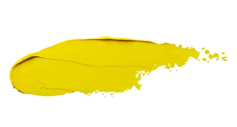 Photo of Yellow oil paint stroke on white background, top view