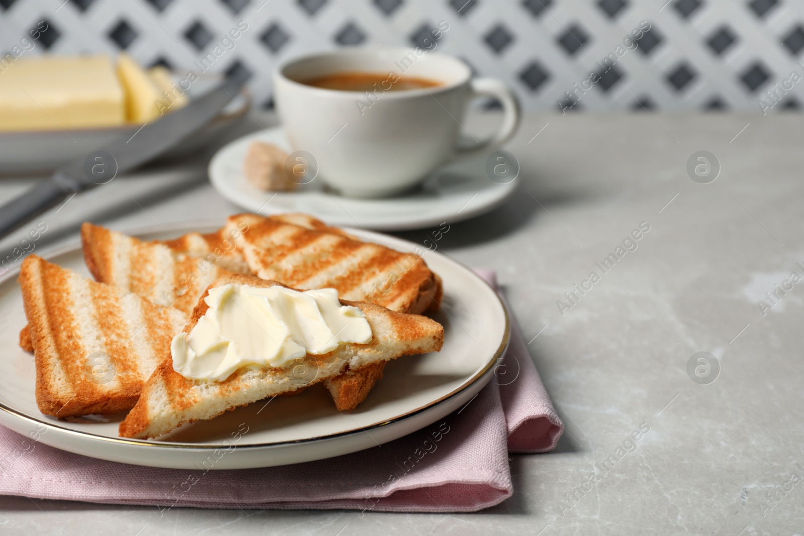 Photo of Tasty toasts with butter on light grey marble table. Space for text