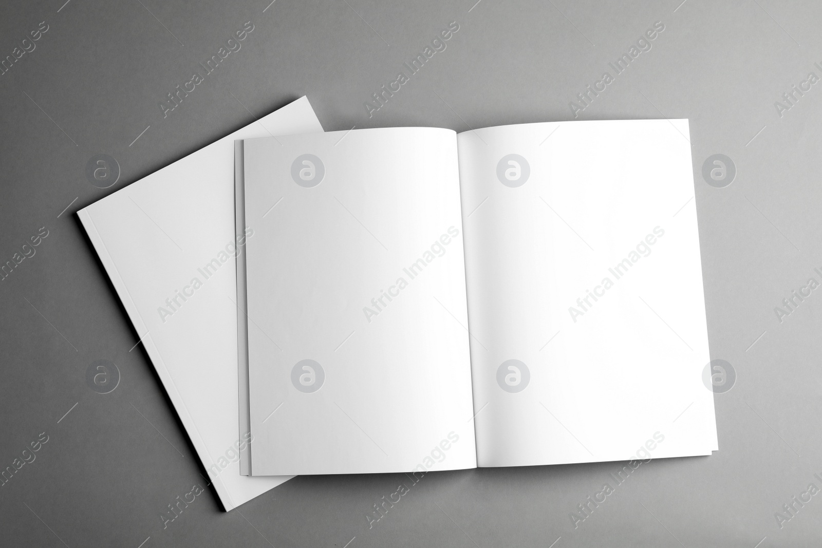 Photo of Open and closed blank brochures on grey background, top view. Mock up for design