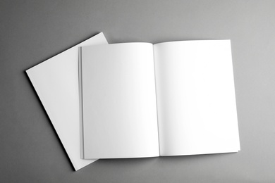 Open and closed blank brochures on grey background, top view. Mock up for design