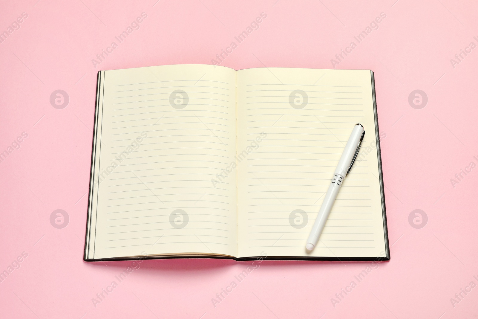 Photo of Open planner with pen on colorful background, above view