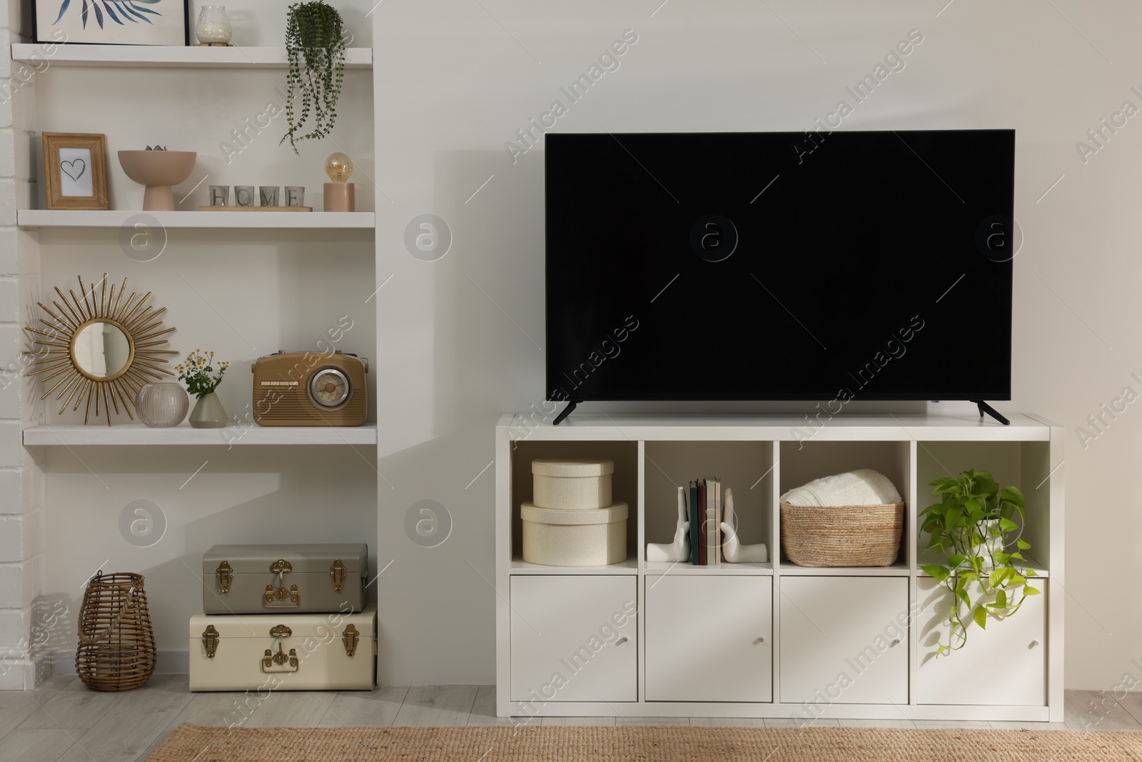 Photo of Stylish wide TV set on stand in room