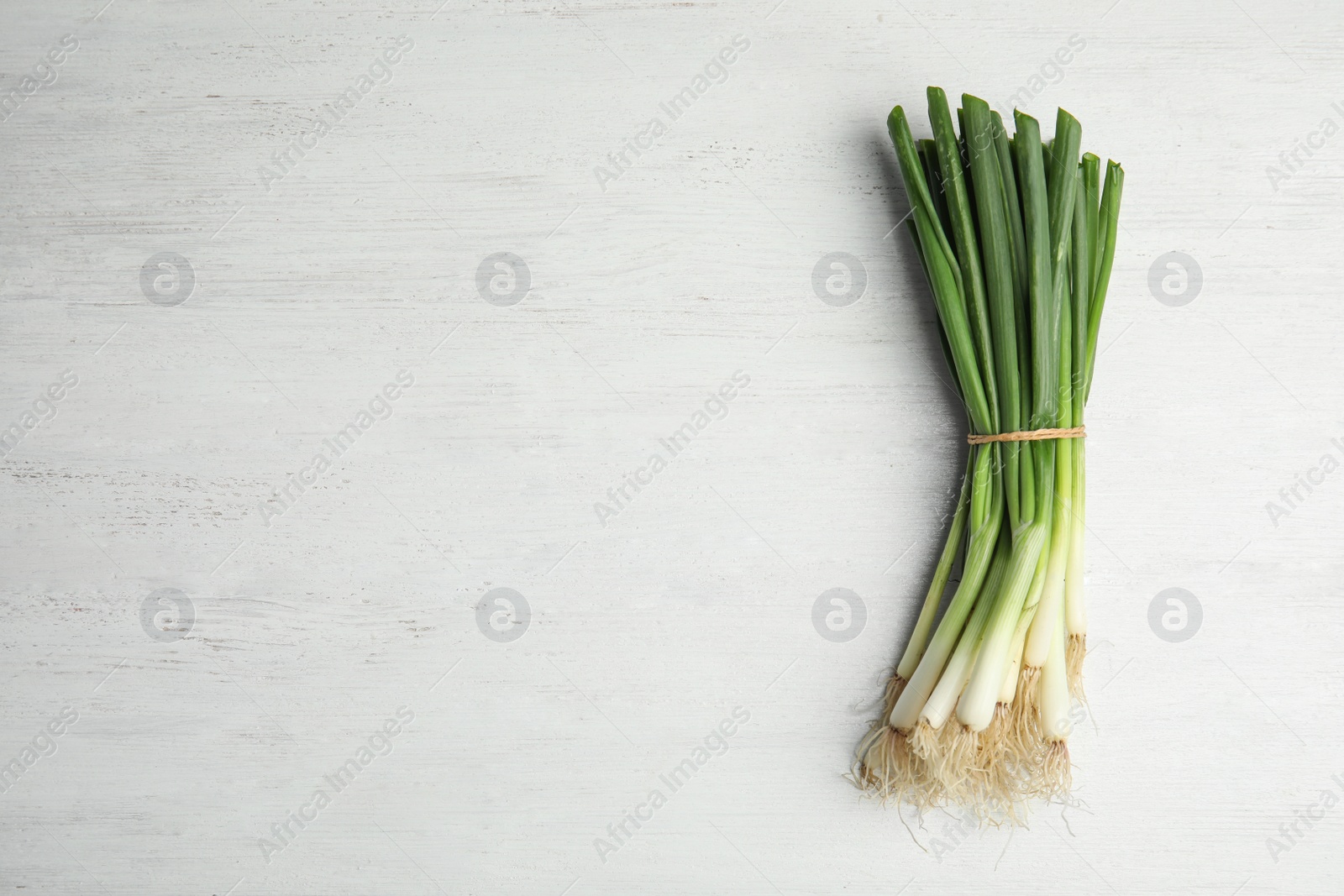 Photo of Fresh green onion on wooden table, top view