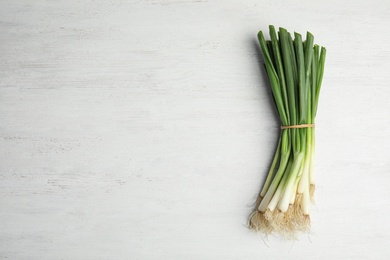 Fresh green onion on wooden table, top view