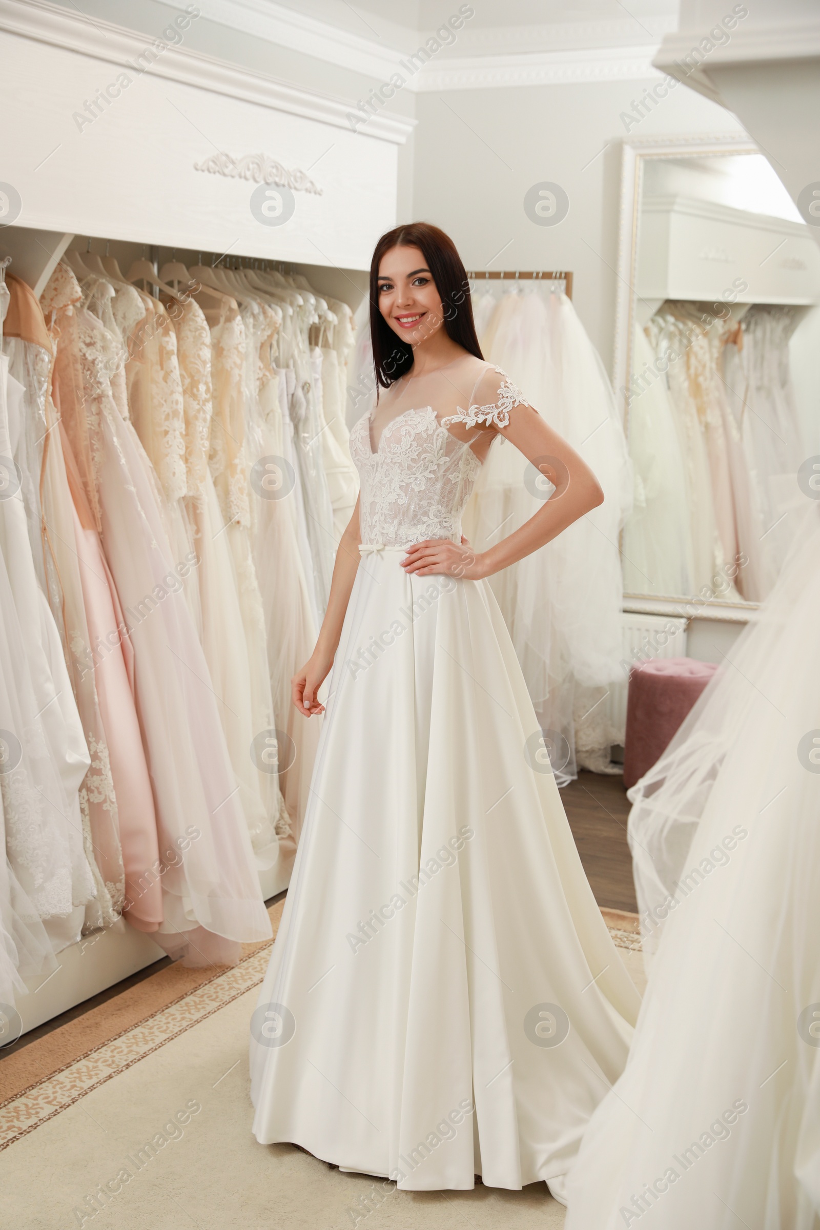 Photo of Woman trying on beautiful wedding dress in boutique