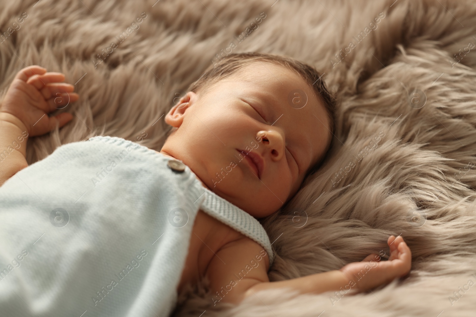 Photo of Cute newborn baby sleeping on fluffy blanket, closeup