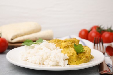 Photo of Delicious rice and chicken with curry sauce on light grey table, closeup