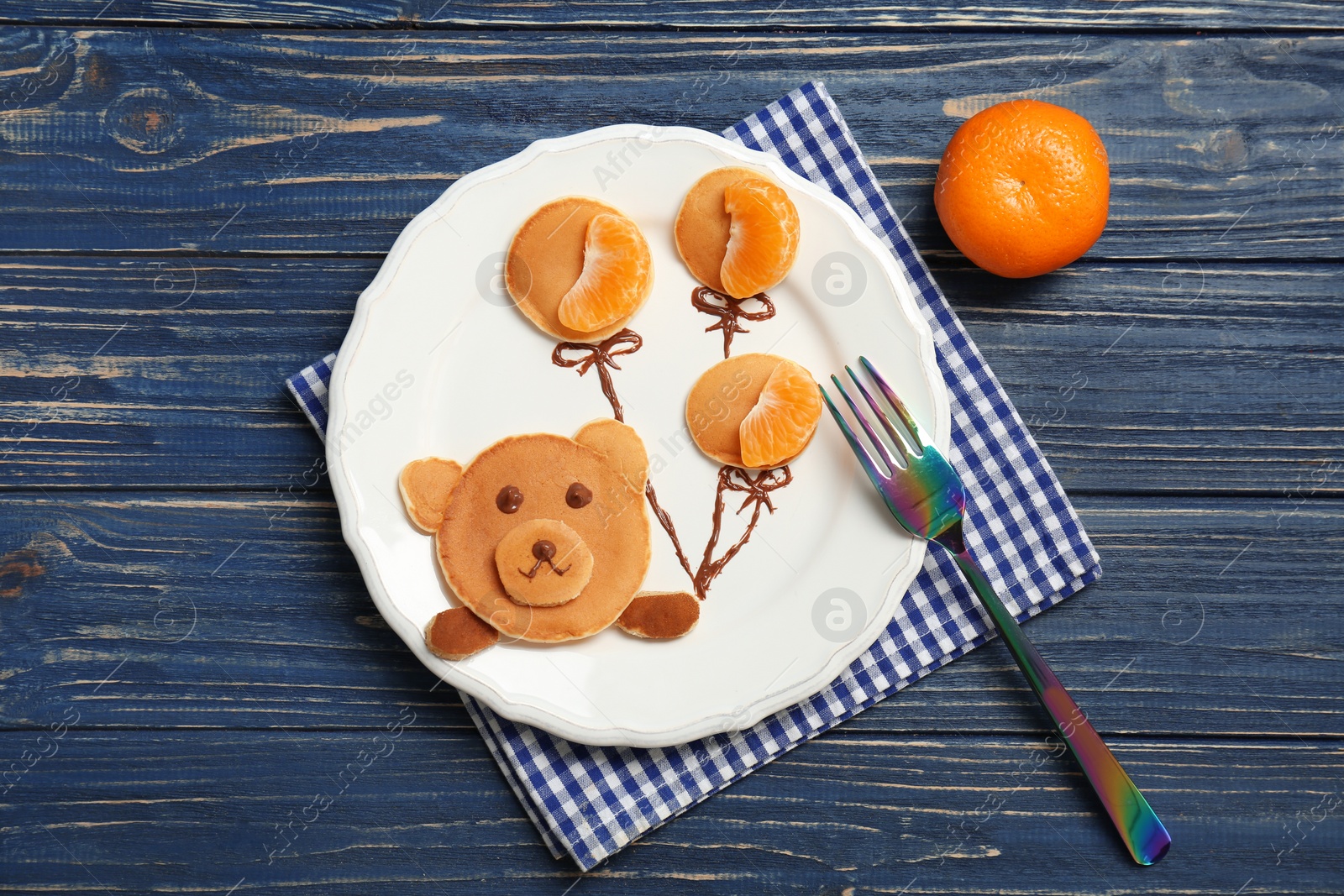 Photo of Flat lay composition with pancakes in form of bear holding balloons on wooden background. Creative breakfast ideas for kids