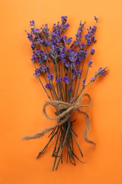 Photo of Bouquet beautiful lavender flowers on orange background, top view