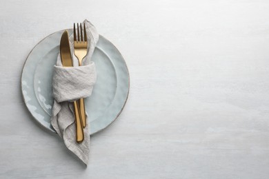 Photo of Stylish setting with cutlery, napkin and plates on white table, top view. Space for text