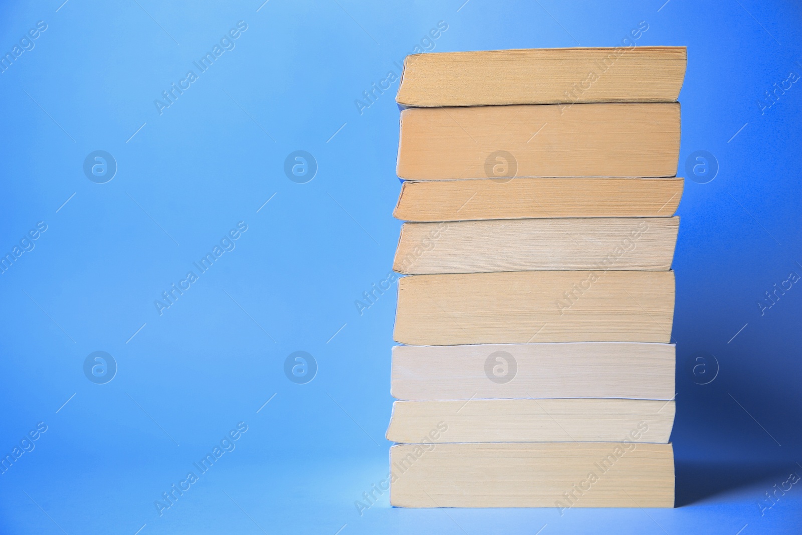 Photo of Collection of books on light blue background, space for text