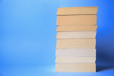 Collection of books on light blue background, space for text