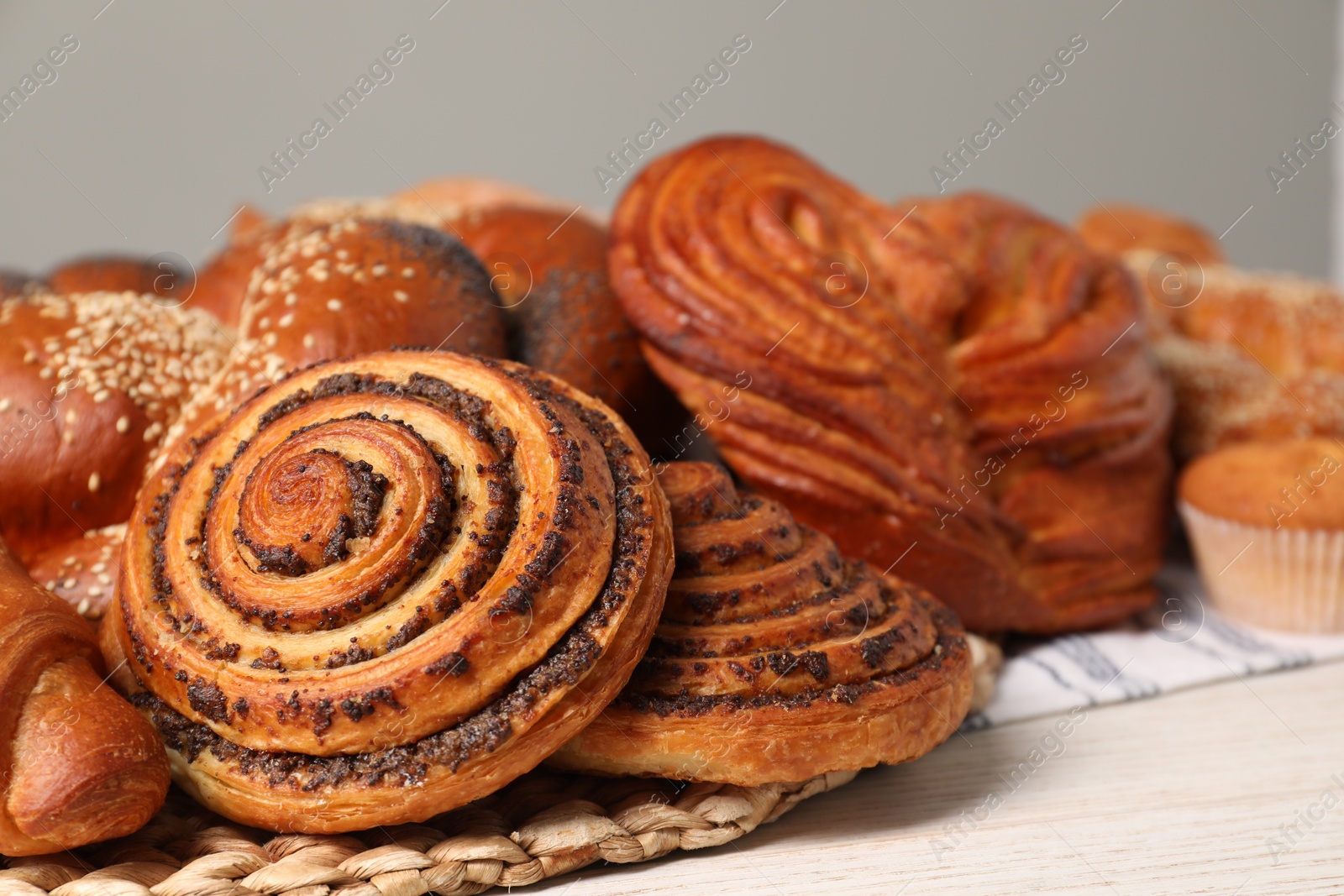 Photo of Different tasty freshly baked pastries on white table, closeup