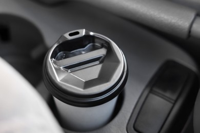 Photo of Coffee to go. Paper cup with tasty drink in holder inside of car, closeup