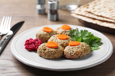 Plate of traditional Passover (Pesach) gefilte fish on wooden table, closeup