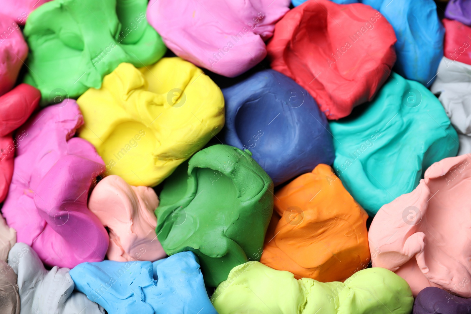 Photo of Pile of colorful plasticine as background, top view