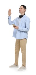 Photo of Young man with headphones and mobile phone waving hand on white background