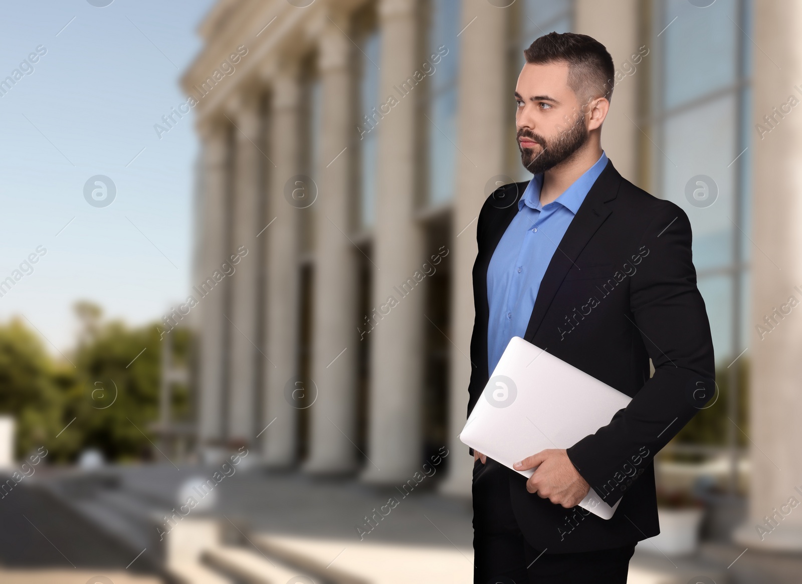 Image of Lawyer with laptop near building outdoors, space for text