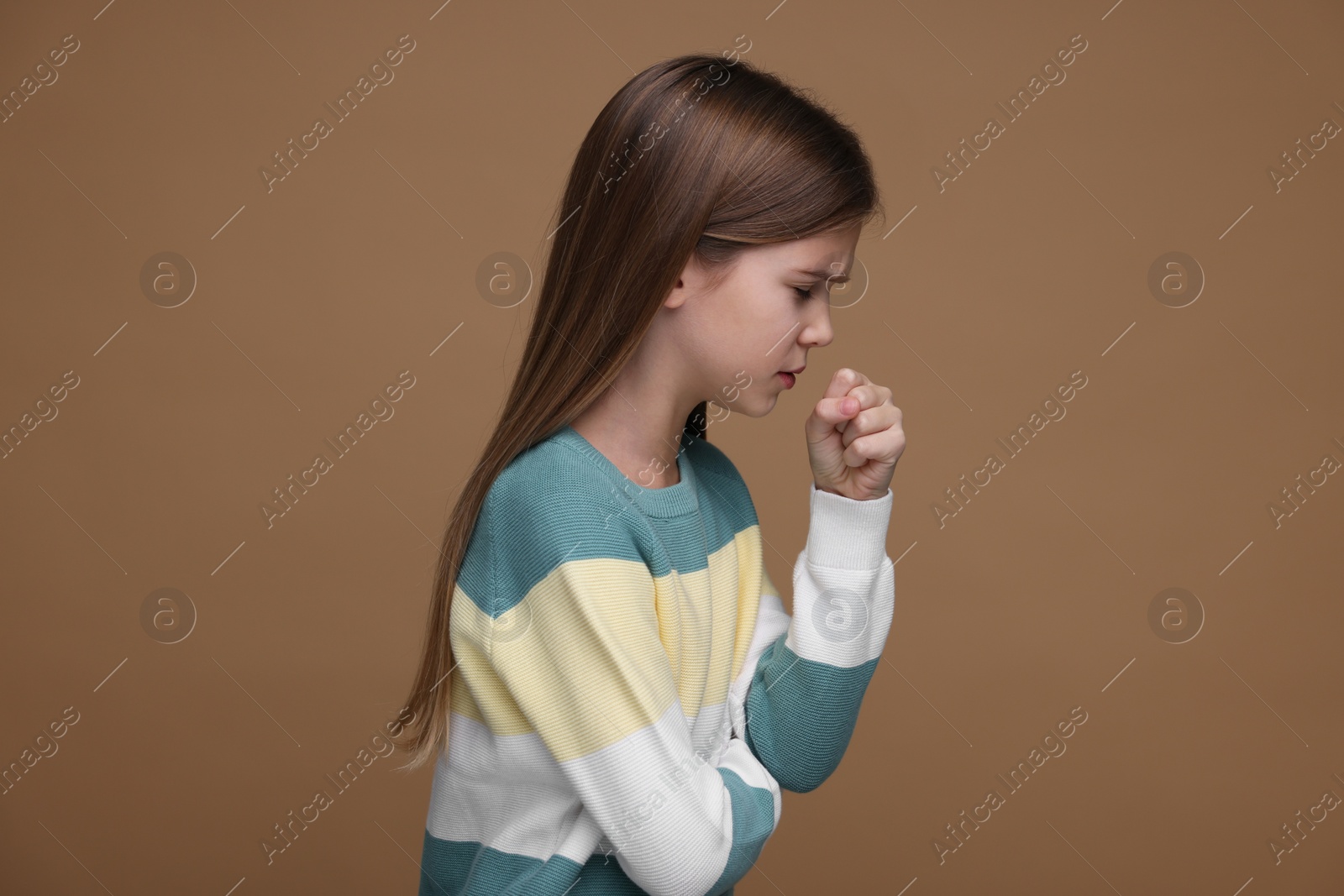 Photo of Sick girl coughing on brown background. Cold symptoms
