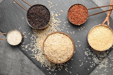 Photo of Flat lay composition with different types of rice on grey table