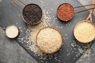 Flat lay composition with different types of rice on grey table