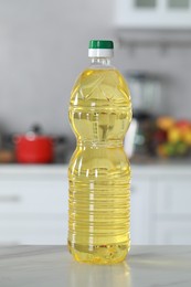 Photo of Bottle of cooking oil on white marble table in kitchen