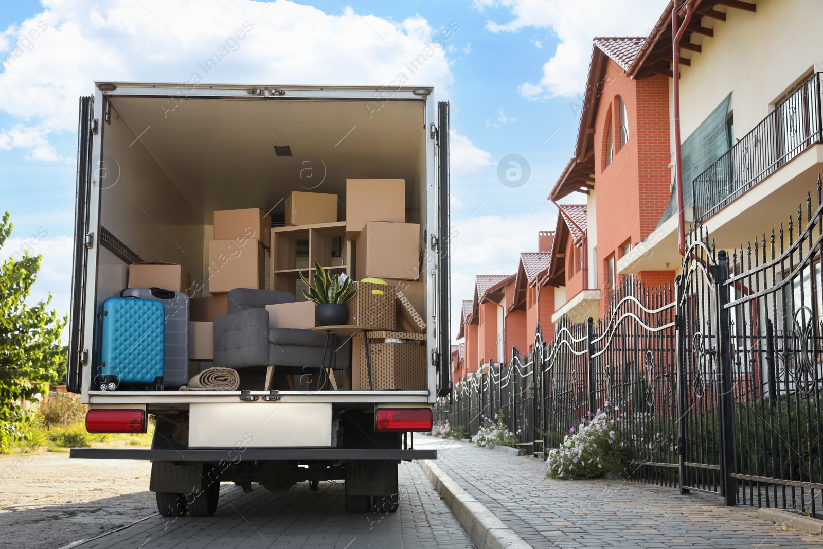 Photo of Van full of moving boxes and furniture near house