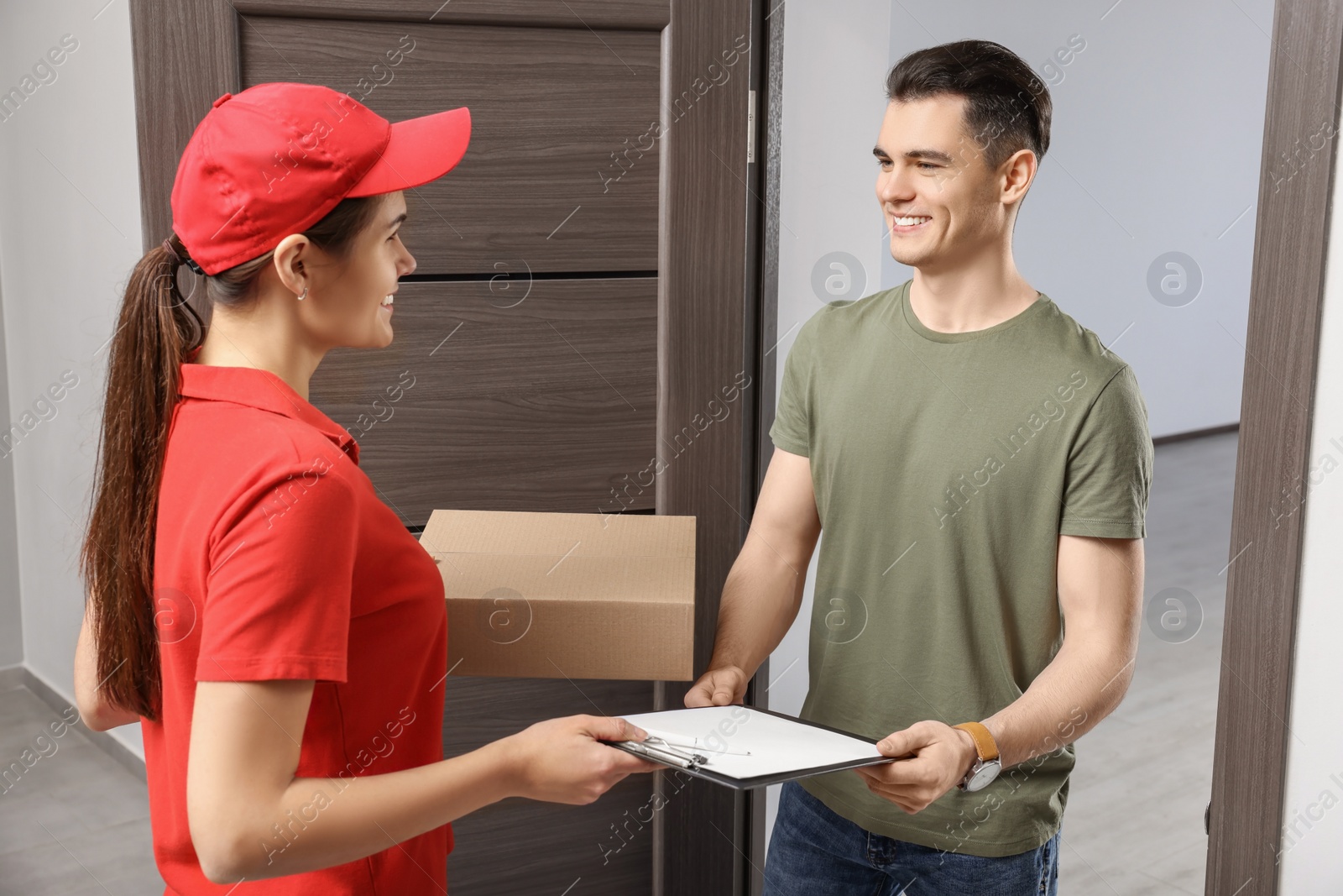 Photo of Man receiving parcel from courier at house entrance