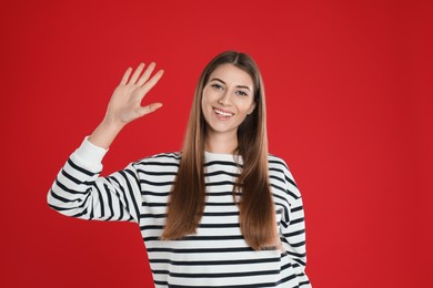Photo of Woman showing number five with her hand on red background