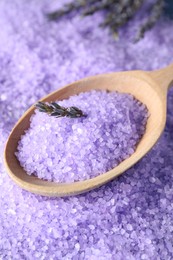 Photo of Spoon with lilac sea salt and lavender flowers as background, closeup