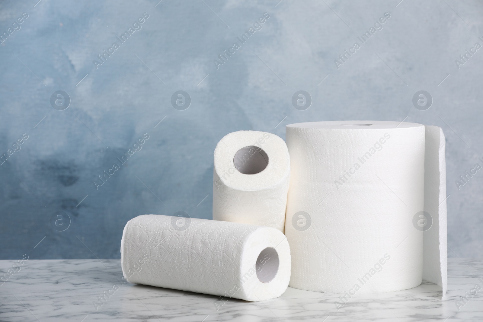 Photo of Rolls of paper towels on white marble table. Space for text