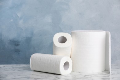 Photo of Rolls of paper towels on white marble table. Space for text