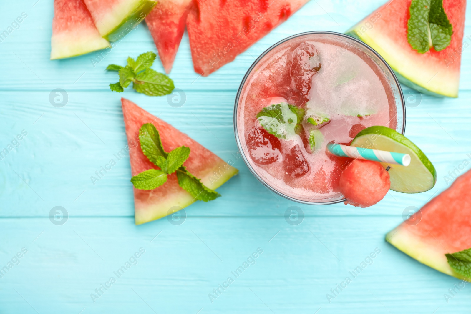 Photo of Delicious fresh watermelon drink on light blue wooden table, flat lay