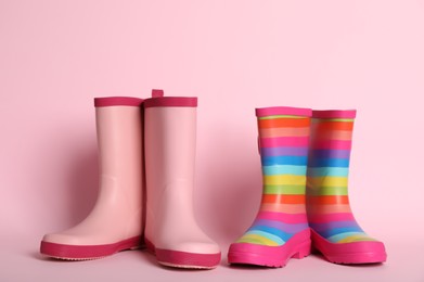 Photo of Two pairs of rubber boots on pink background