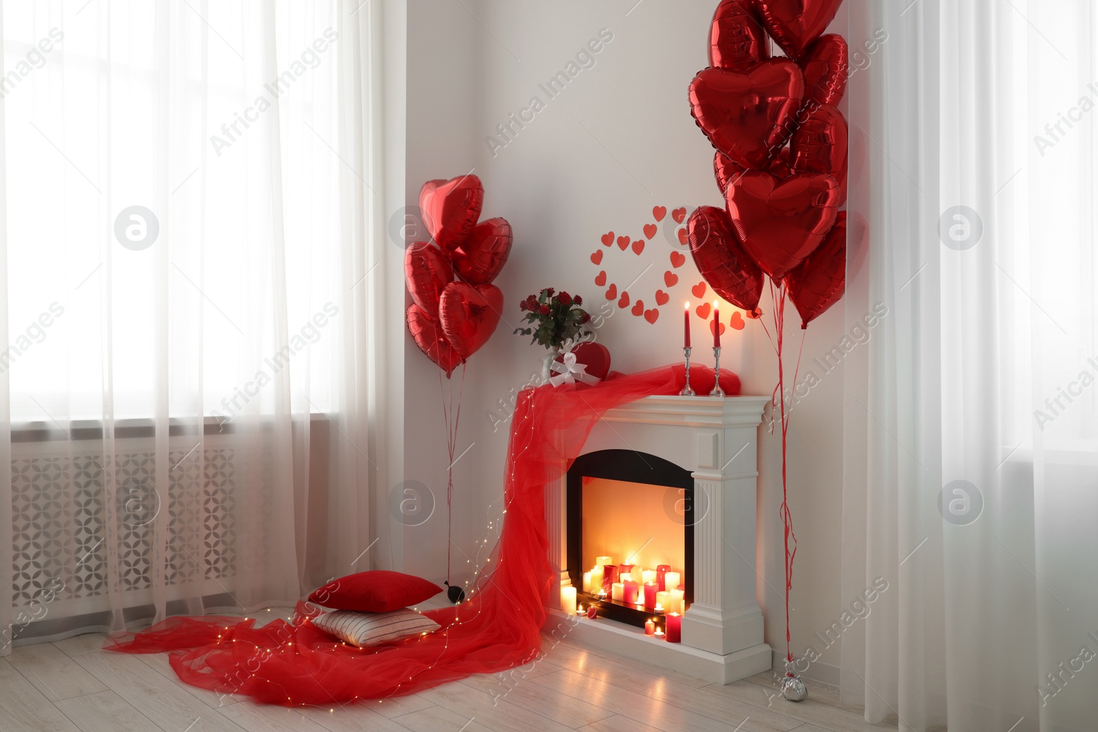 Photo of Stylish room with fireplace and Valentine's day decor. Interior design