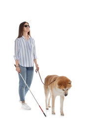 Blind woman with walking stick and dog on leash against white background