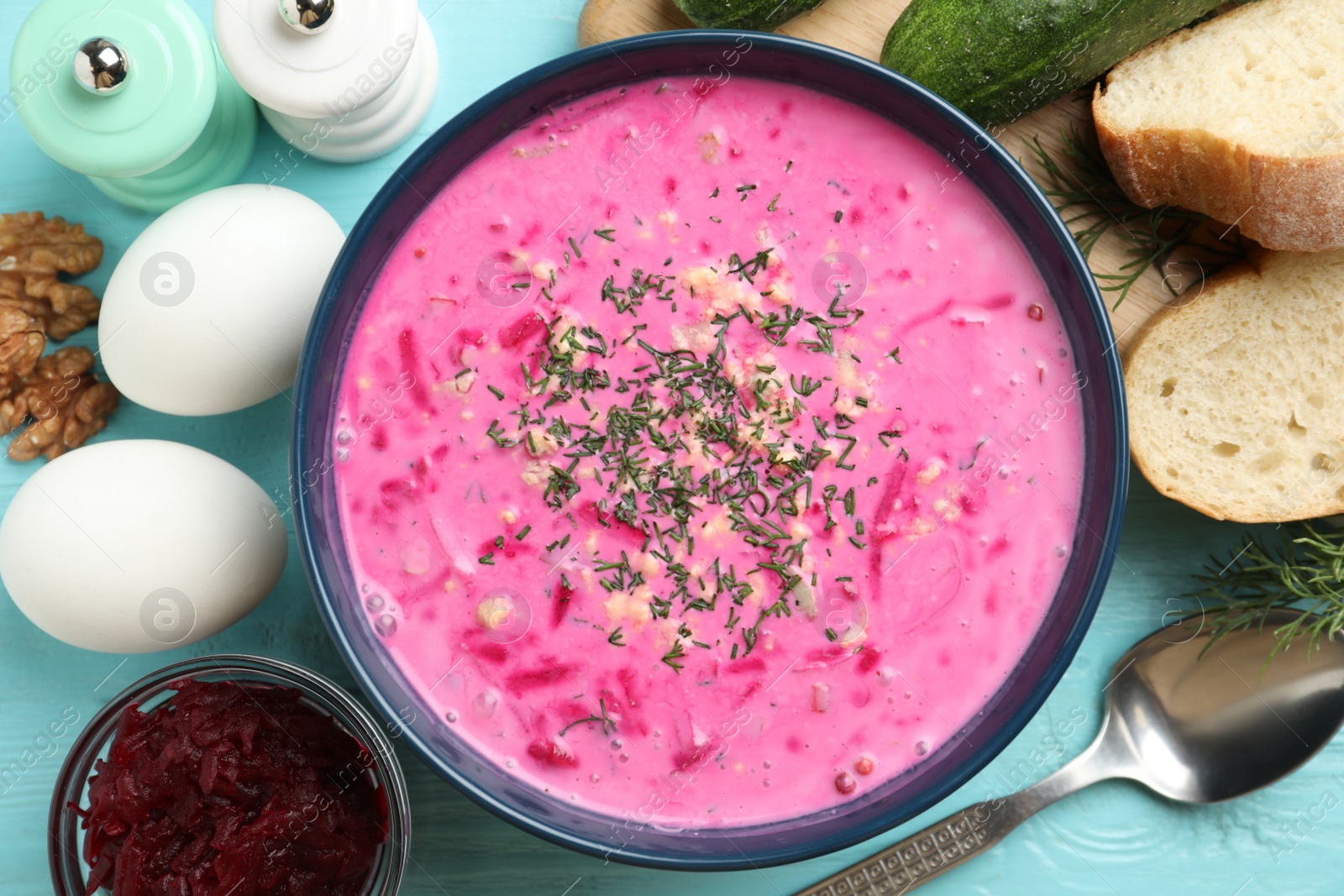 Photo of Delicious cold summer beet soup on light blue wooden table, flat lay