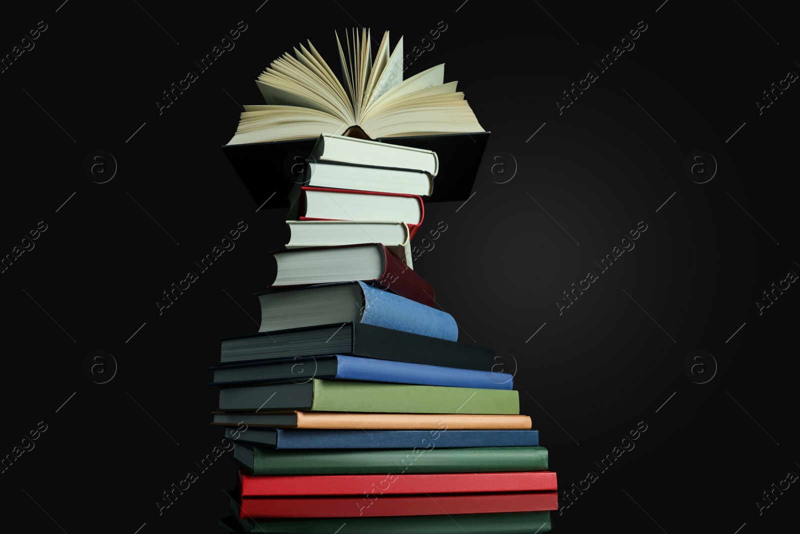 Photo of Stack of different hardcover books on black background