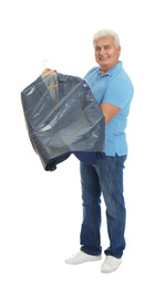 Senior man holding hanger with jacket in plastic bag on white background. Dry-cleaning service
