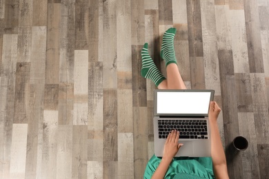 Photo of Top view of woman with laptop sitting on floor, closeup. Mockup for design