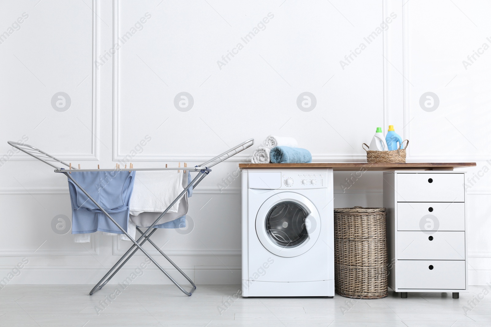 Photo of Clean laundry hanging on drying rack indoors